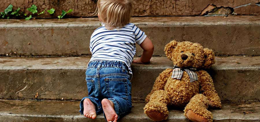 Child climbing steps and a teddy